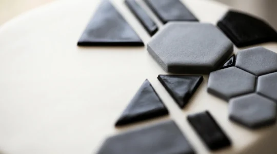 Détails de formes géométriques parfaitement découpées en pâte à sucre et chocolat sur un gâteau moderne