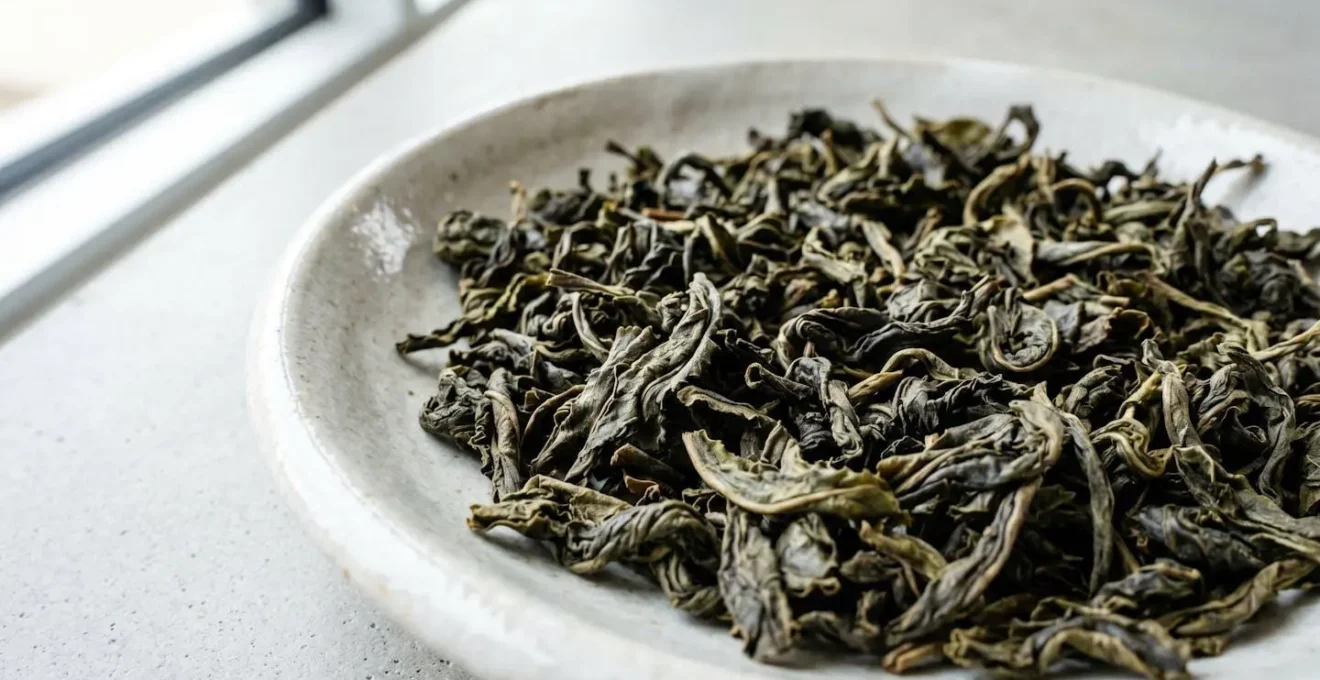 Gros plan sur des feuilles de thé oolong dans une coupelle en céramique contemporaine